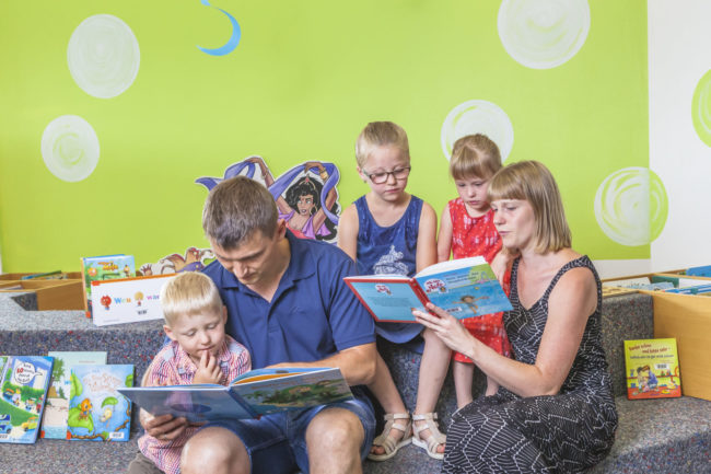 Familie in Bücherei Familie, Bücherei, Bibliothek, Buch, Lesen, Eltern, Kinder, Vorlesen
